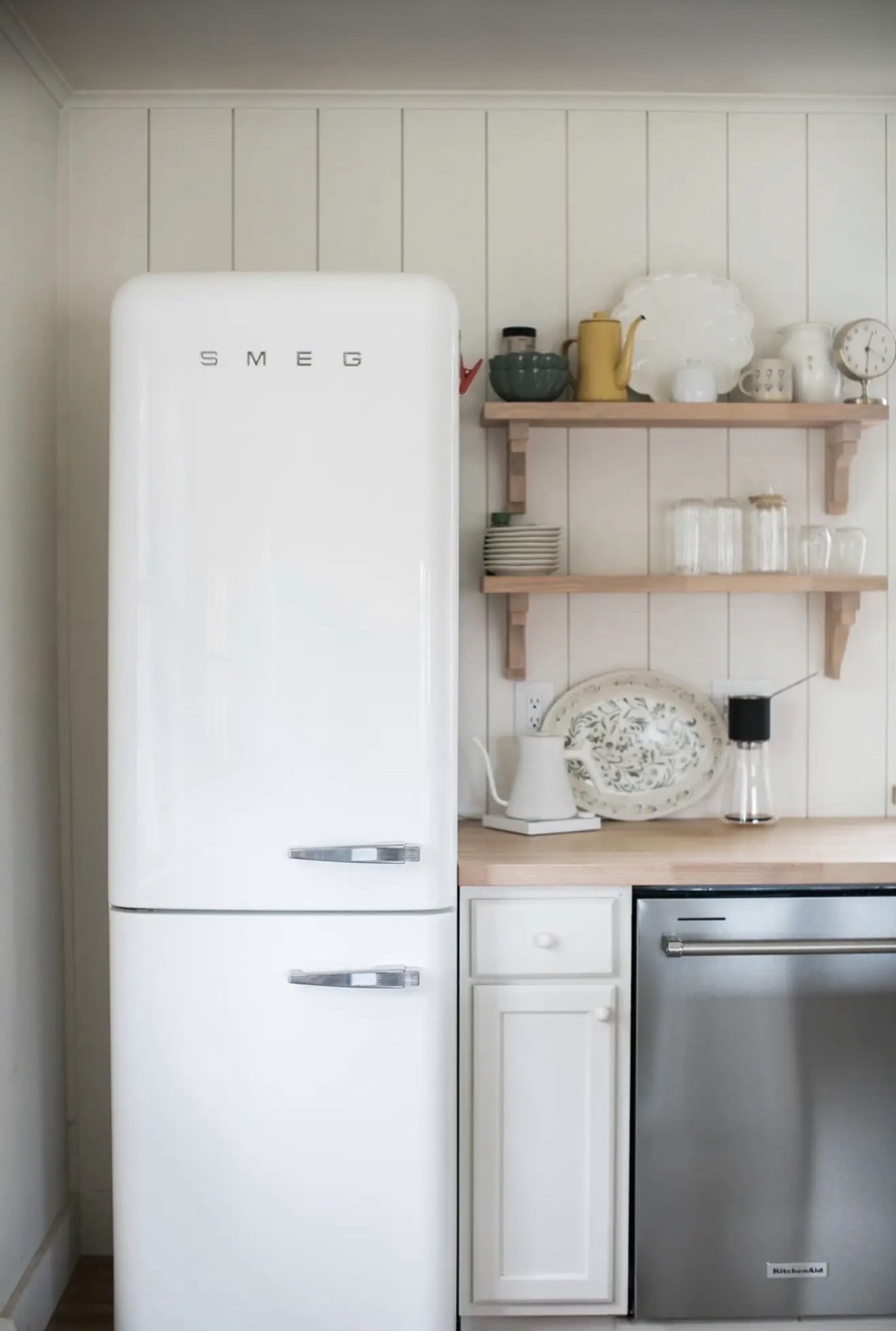 White retro refrigerator, open wood shelves and handcrafted kitchen details