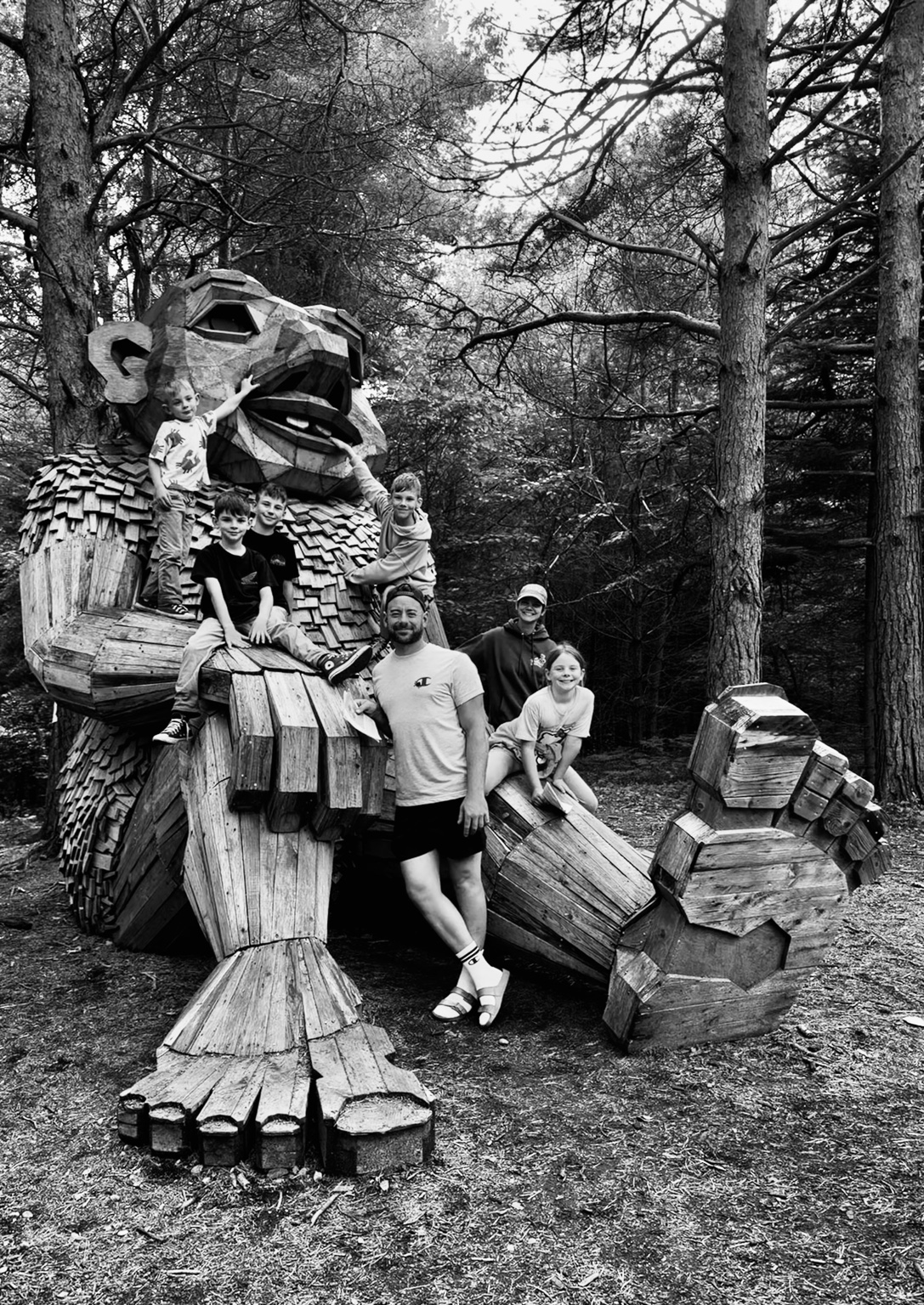 Gabriel Bahrke with his five children outdoors among handmade wooden sculptures
